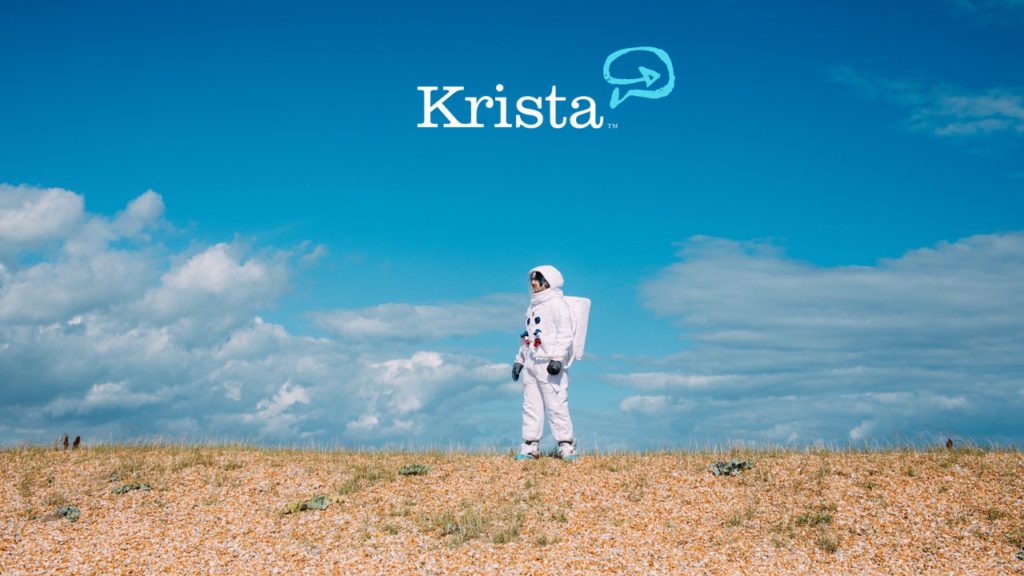 A men wearing astronaut suit standing on land and white krista logo in the top